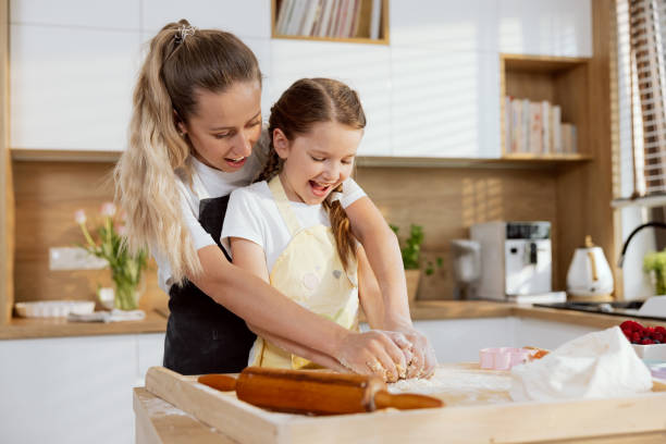 istock In the beautiful modern kitchen adorable young motheer teaching small schooler kid knead dough with hands preparing homemade cookies bakery. Having fun together talking 1415561676