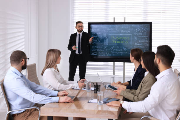 istock Business trainer near interactive board in meeting room during presentation 1415564336