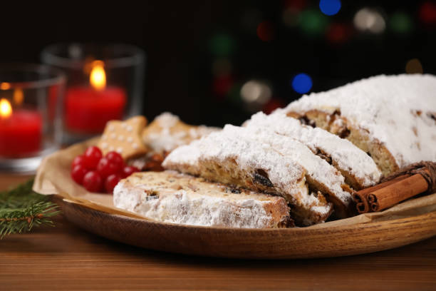 istock Traditional Christmas Stollen with icing sugar on wooden table, closeup 1415564343