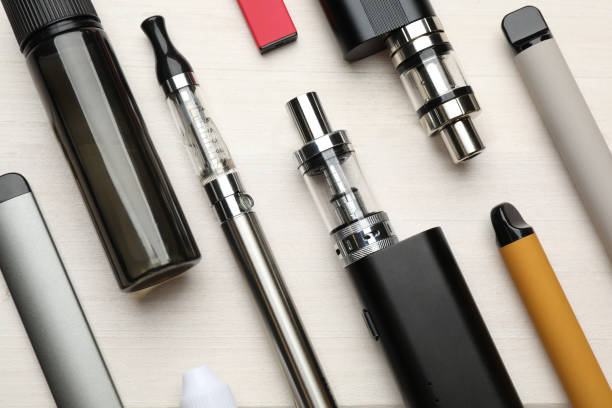 Different electronic cigarettes on white wooden table, flat lay. Smoking alternative Different electronic cigarettes on white wooden table, flat lay. Smoking alternative electronic cigarette stock pictures, royalty-free photos & images