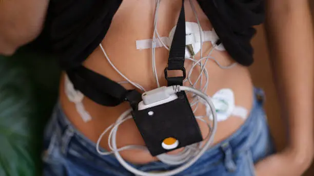 Woman wears device, device for daily ECG monitoring. Treatment of heart defects and cardiac examinations of heart