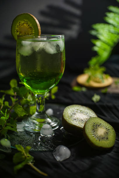A glass of refreshing and cold lemon and orange juice with ice cubes in it, showing a natural yellow hue. There are water droplets on the surface of the drink, which adds a cool feeling in the summer. This drink is suitable for healthy drinks and summer cooling photography.