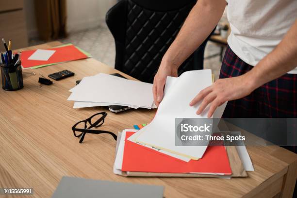 Man Intensely Sorting A Man Is Sorting Through Documents Needed For Work On His Desk A Man In ...