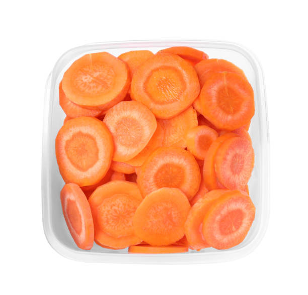 istock Fresh sliced carrots in plastic container isolated on white 1415566407