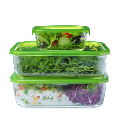 Glass containers with fresh food on white background