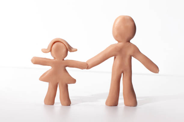 father and daughter clay figures holding hands