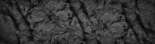 istock Black white rock texture background. Rough mountain surface with cracks. Close-up. Stone. Basalt. 1415569753