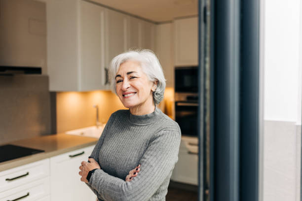 istock Silver-haired woman smiling at the camera at home 1415569932