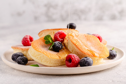 Japanese soft pancakes with berries sprinkled with powdered sugar