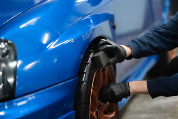 istock applying black car tire polish on the wheels 1415571315