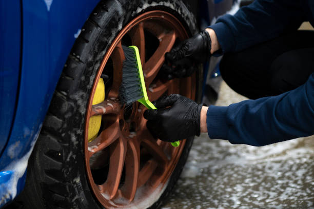 istock cleaning the car wheel with a brush, workshop auto service 1415571361
