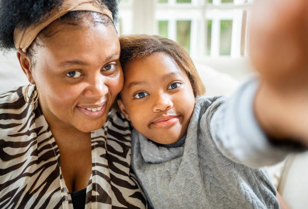 istock Small girl taking selfie with mother 1415572110