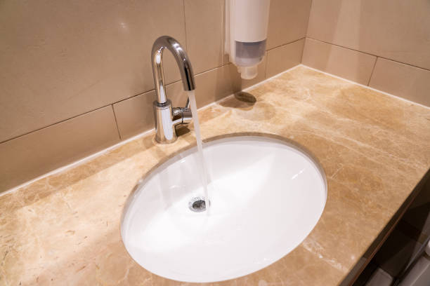 istock Water flows from a faucet into a sink in a modern interior 1415572137