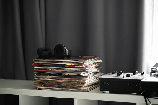 vinyl music records stack on the shelf with headphones on top
