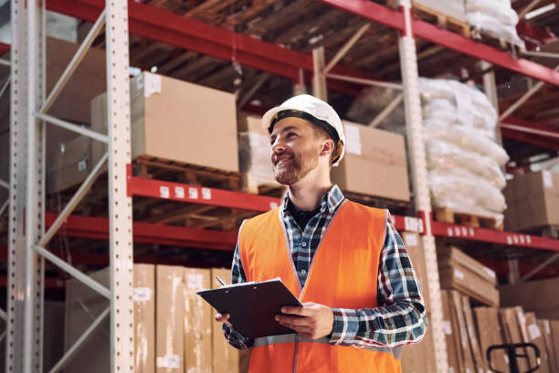 istock Positive mood. Employee in uniform is working in the storage at daytime 1415574273