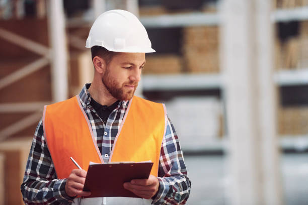 istock Positive mood. Employee in uniform is working in the storage at daytime 1415574277