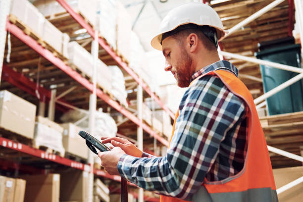 istock With tablet. Employee in uniform is working in the storage at daytime 1415574430