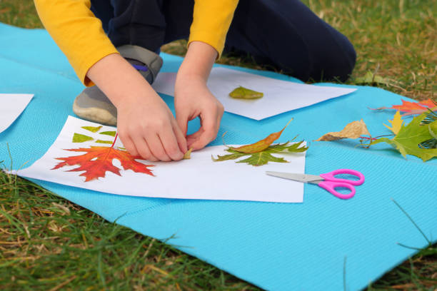 istock Diy art kid creative play learning outside school outdoor learning park school. Kids workshop children glue scissors art craft kids handmade autumn child art education nature creative autumn leaves 1415574515