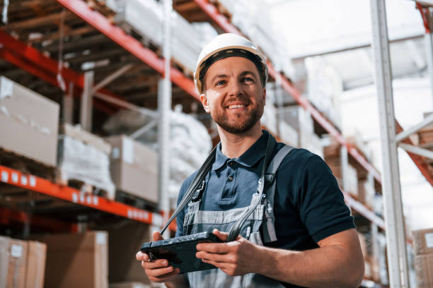 istock With digital tablet in hands. Employee in uniform is working in the storage at daytime 1415574557