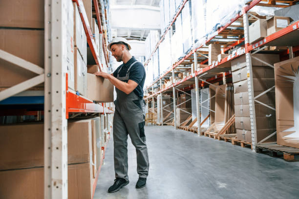 istock Taking out the box. Employee in uniform is working in the storage at daytime 1415574768
