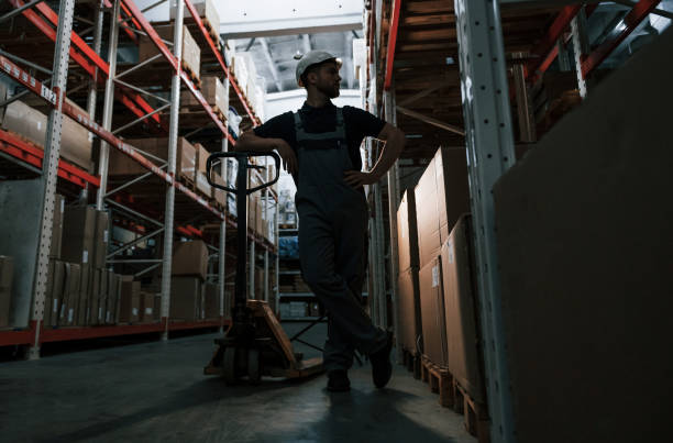 istock With platform trolley. Employee in uniform is working in the storage at daytime 1415575287
