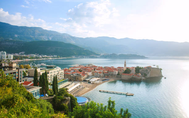 vista aerea del paesaggio sui tetti della vecchia città storica di budva e baia del mare, montagne e foreste del montenegro, sullo sfondo del cielo blu - budva foto e immagini stock