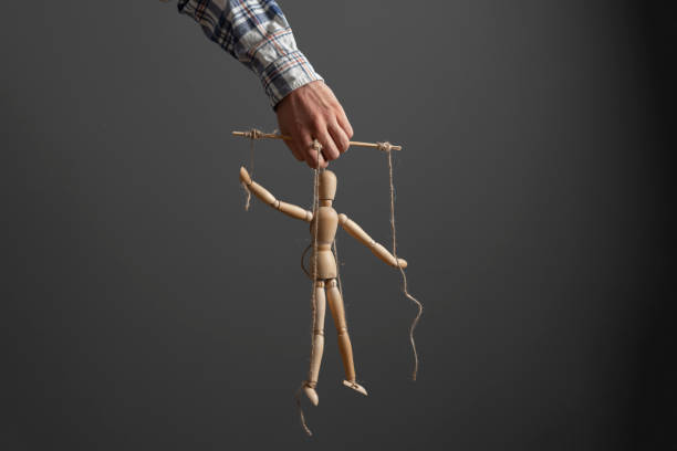 istock emploee holding a marionette wooden doll, manipulation concept 1415576366