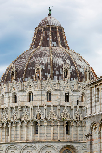 Pisa, Italy - May 13, 2019: Pisa Baptistery of St. John on Piazza del Duomo. It is a 12th century Roman Catholic church building next to Pisa Cathedral and Leaning Tower of Pisa