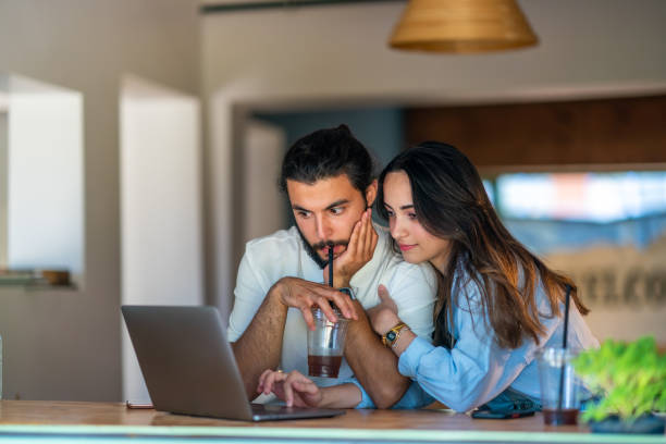 istock Young couple using laptop in a coffee shop 1415577913
