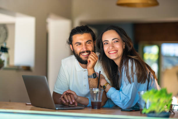 istock Young couple using laptop in a coffee shop 1415577951