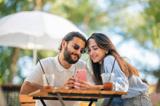 istock Young couple using mobile phone at coffee shop 1415579148