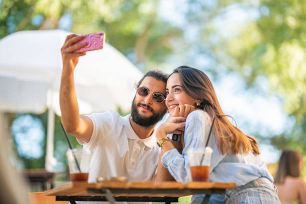 istock Young couple using mobile phone at coffee shop 1415579387