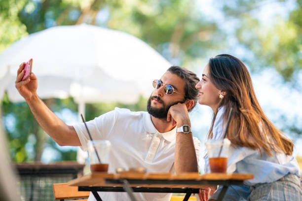 istock Young couple using mobile phone at coffee shop 1415579388