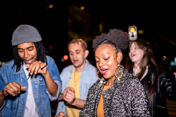 istock Group of friends dancing outside at night 1415579545