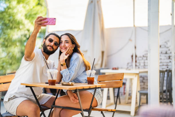 istock Young couple using mobile phone at coffee shop 1415579633