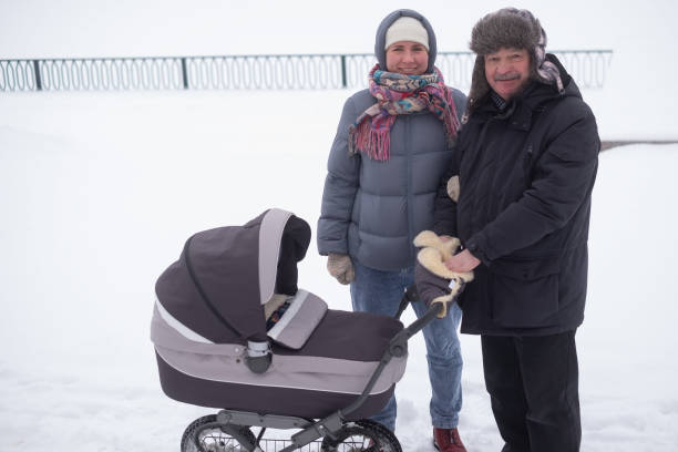 istock Mother and grandfather walking with child in stroller 1415581019