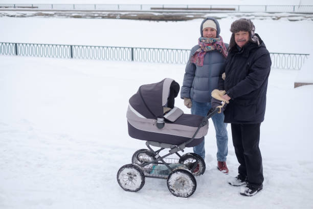 istock Mother and grandfather walking with child in stroller 1415581049