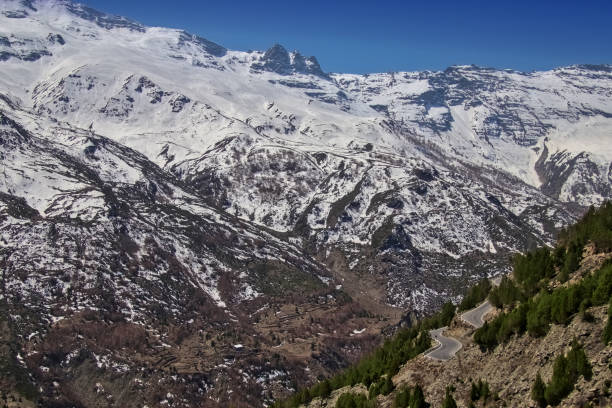 istock Mountain road with snowy mountains in the background 1415582615