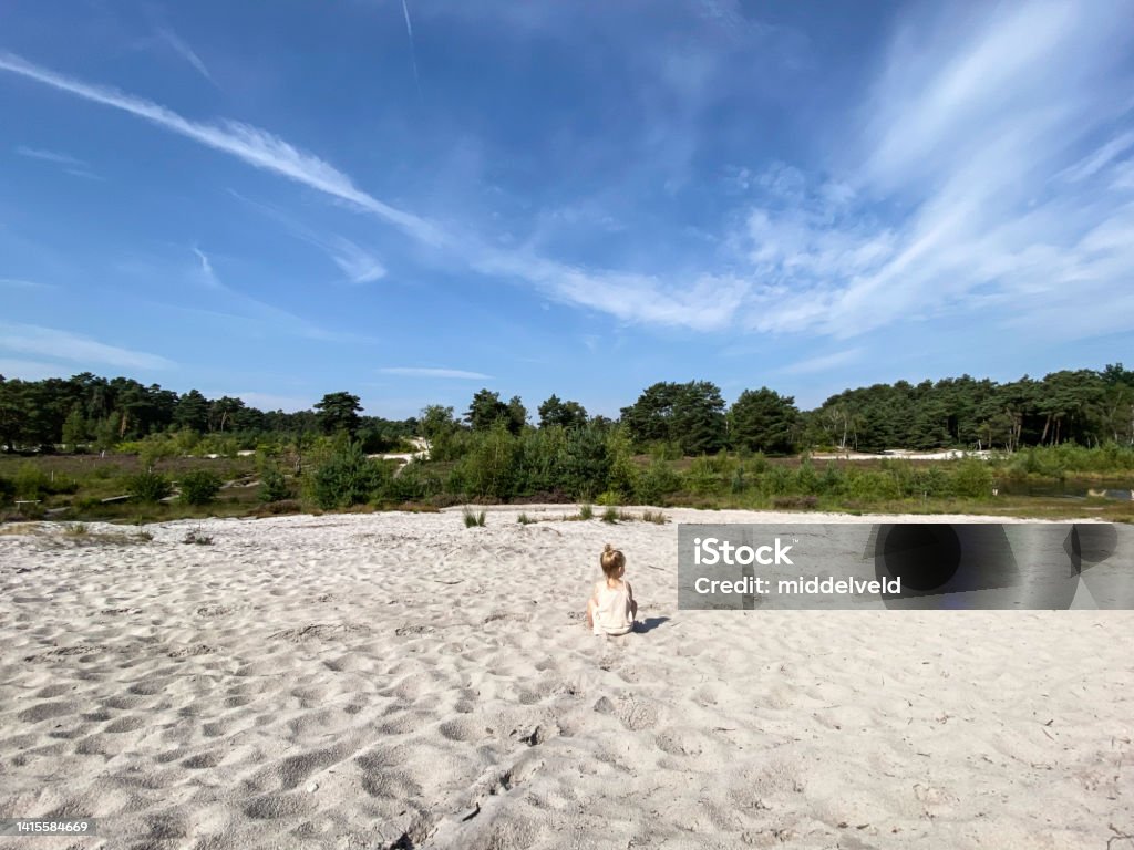 Toddler girl playing in the sand Toddler girl playing in the sand on a warm summer day Sand Dune Stock Photo