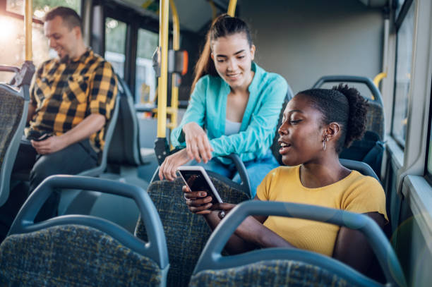istock Multiracial group of friends talking while riding in a bus and using a smartphone 1415585906
