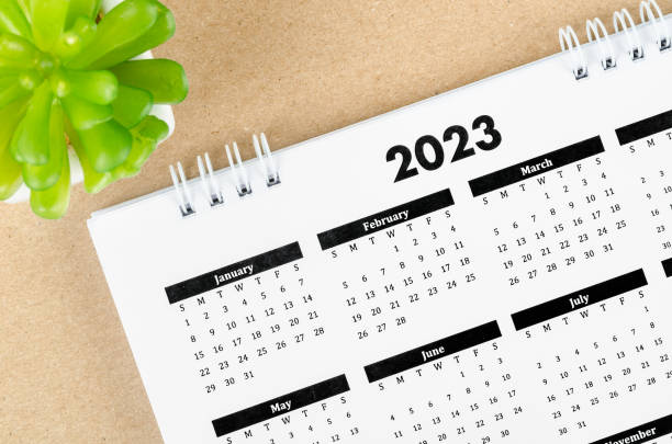 The 12 months desk calendar 2023 on wooden background. stock photo