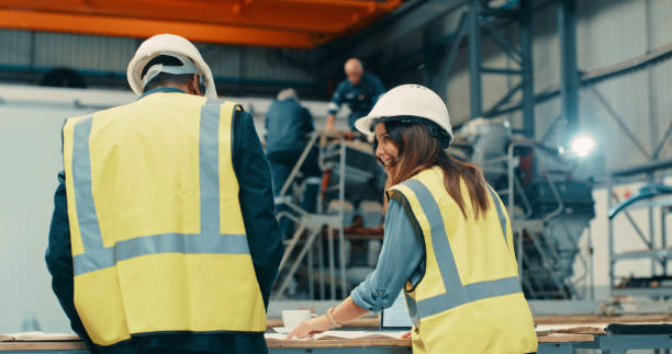 istock Workers, construction and team talking about building design in the warehouse. Teamwork, management and discussion of new ideas for a project. Industrial people chat about production on site. 1415590765