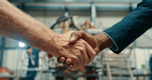Handshake, deal or industrial agreement after a successful b2b collaboration meeting in a factory warehouse. Men shaking hands in compliance and sealing a business contract for a trustworthy company stock photo