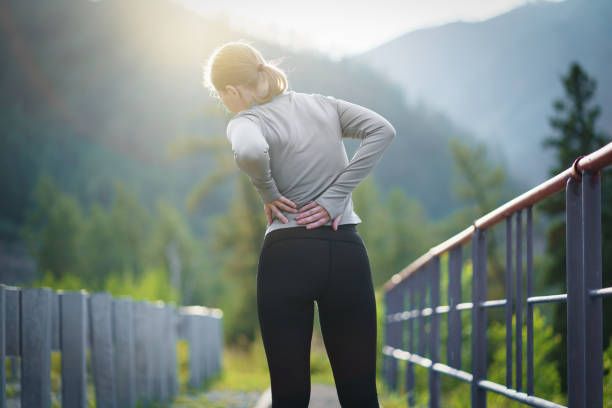 스포츠 부상으로 고통스러운 허리를 마사지하는 여성 - 허리통증 뉴스 사진 이미지