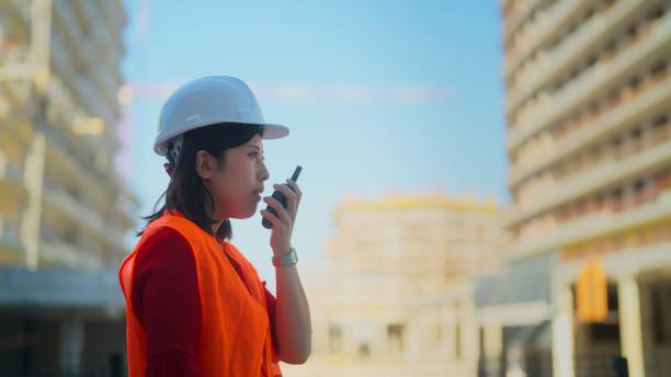 istock Female construction worker walking on walkie-talkie 1415592128