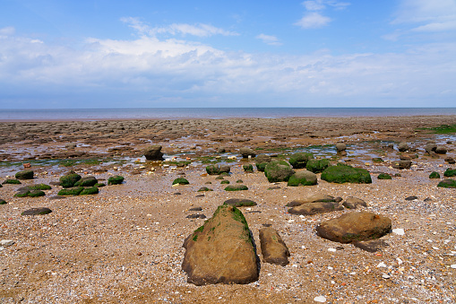 Rocks of all shapes and sizes cover Hunstanton beach at low tide.