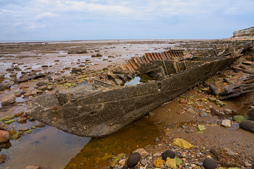 The rusted hull of the ST Sheraton on Hunstanton beach at low tide.