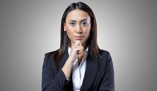 Portrait of confident young female worker isolated on grey background.