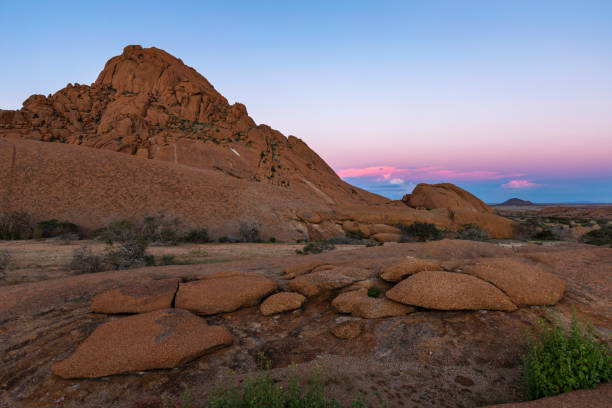 istock Red granite kopje and pink clouds after sunset 1415597944