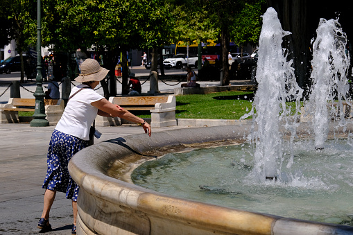 People cool off in fountain during a hot day in central Athens, Greece on August 18, 2022.